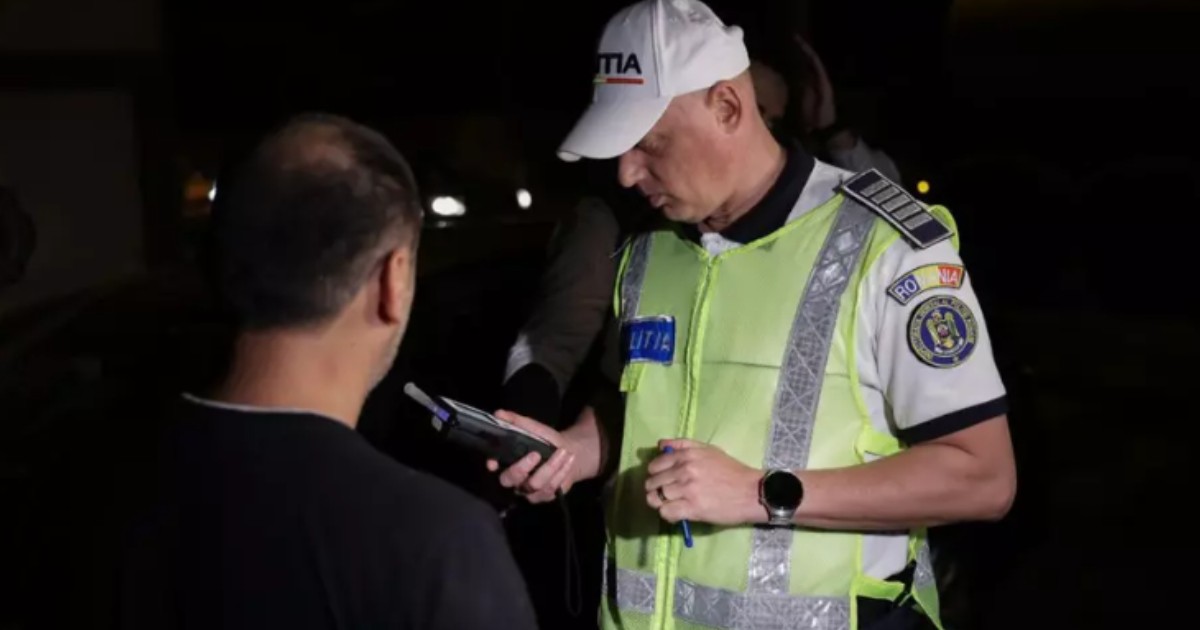 Un polițist care testează cu aparatul alcooltest un bărbat.