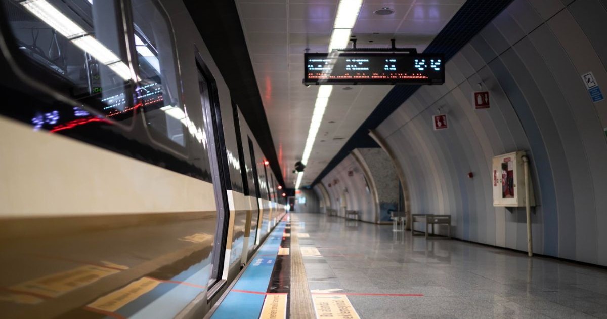 stație de metrou goală, cu un tren subteran care ajunge în stație
