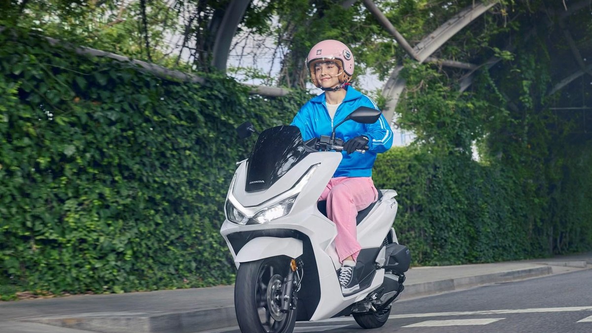Femeie tanara pe scuter alb Honda de 125 cm