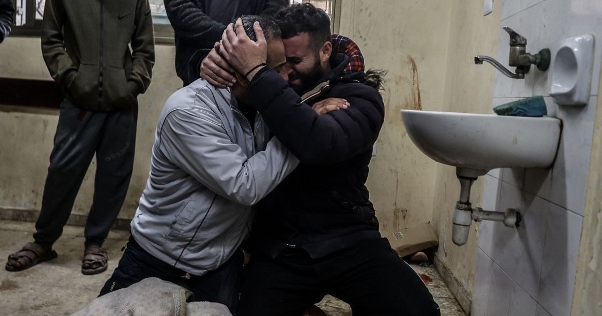 Palestinienii plâng lângă cadavre într-un spital
