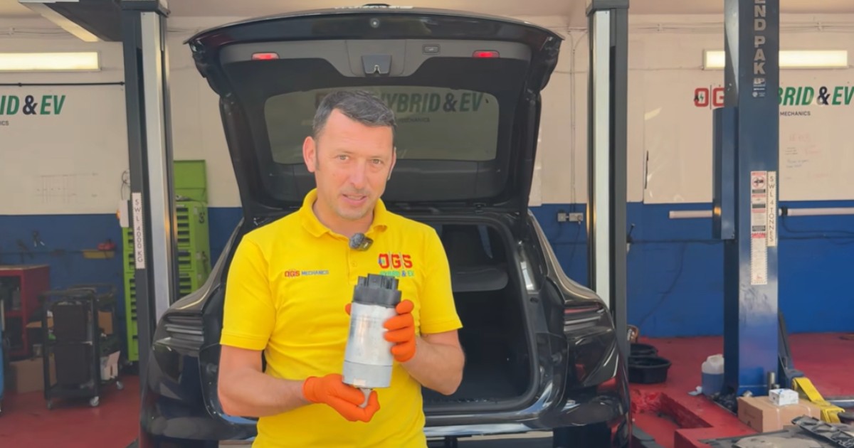 Un bărbat care poartă un tricou galben și se află într-un service auto