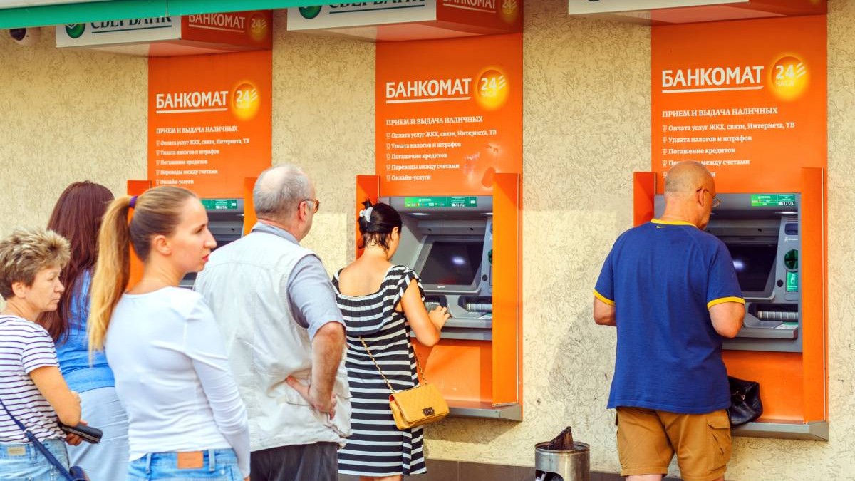 Oameni stau la coadă la bancomate să scoată bani numerar