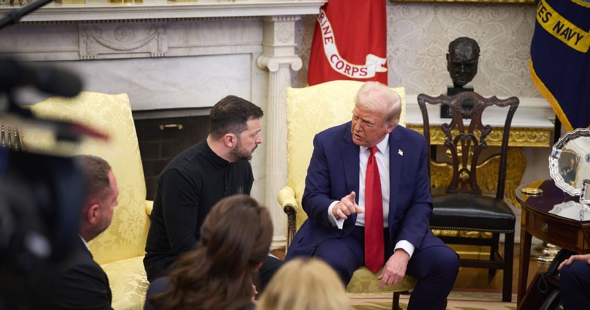 Doi bărbați stau pe două fotolii și discută. Cel din dreapta, Donald Trump, e în costum și are cravată roșie. Cel din stânga, Volodimir Zelenski, poartă un pulover închis la culoare