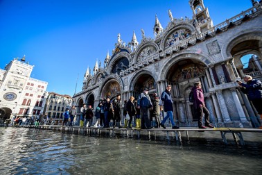 Oamenii trec pe podețe improvizate pentru a vizita Veneția (foto EPA)