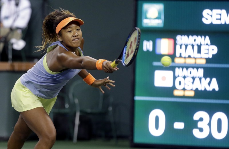 Naomi Osaka, întinzându-se după minge în timpul unei partide cu Simona Halep. (FOTO: EPA)
