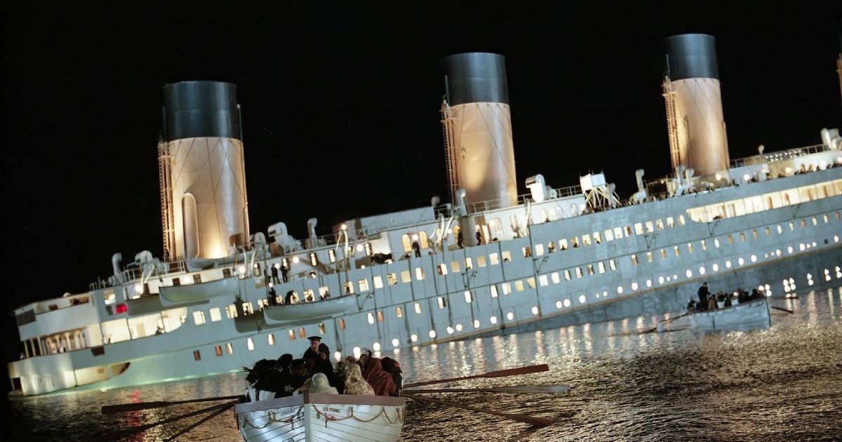 o scena de film cu un vas care se scufunda pe apa, cu o braca de salvare plina cu oameni