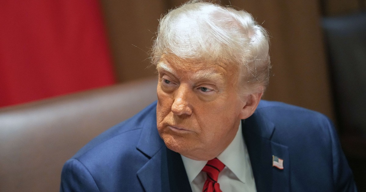 În imagine este ilustrat Donald Trump, îmbrăcat în costum albastru închis, cămașă albă și cravată roșie