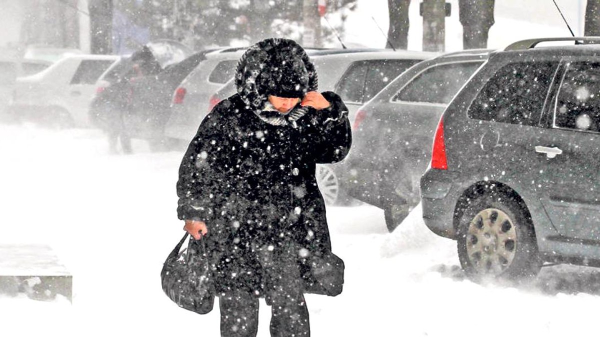 Prognoza meteo pentru perioada 26 noiembrie-9 decembrie. Femeie care înfruntă ninsoarea