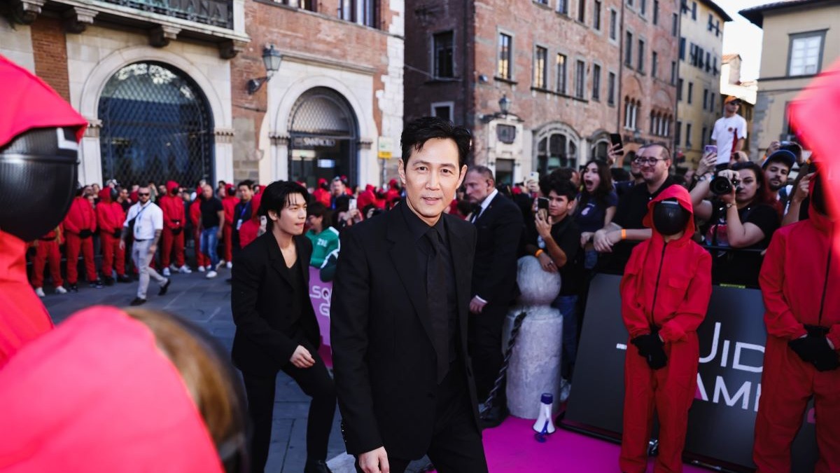 Îmbrăcat elegant, creatorul Squid Game Hwang Dong-hyuk ajunge pentru photocall-ul conferinței de presă din sezonul 2