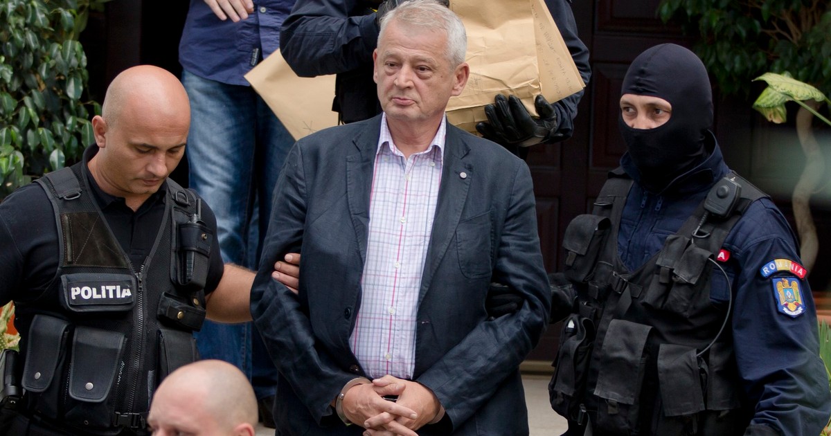 Ofițeri de poliție l-au escortat pe primarul orașului București, Sorin Oprescu, încătușat, de la casa sa din Ciolpani, România, duminică, 6 septembrie 2015. Procurorii anticorupție din România l-au reținut pe influentul primar al Bucureștiului duminică dimineața, sub suspiciunea că a luat mită de 25.000 de euro (28.000 de dolari americani) de la firme care lucrau pentru primărie