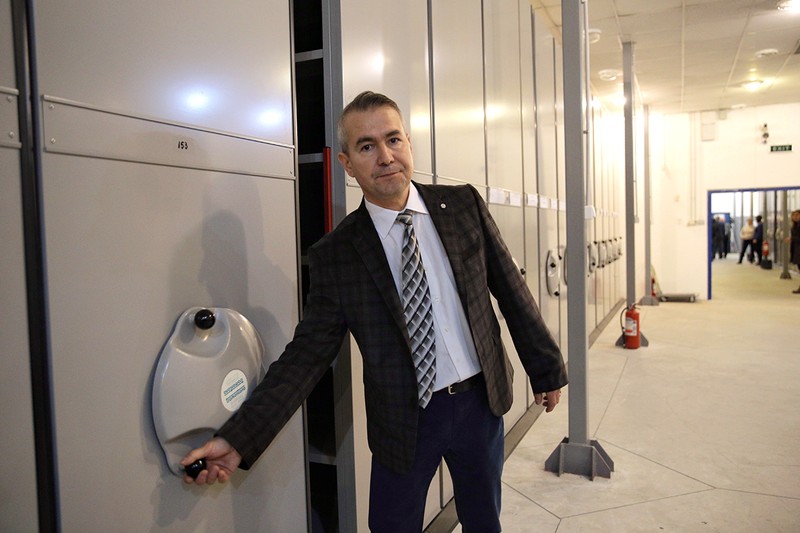 Ionel Ivașcu în fața dulapurilor de arhivă în care sunt ținute dosarele Fondului Informativ și Penal