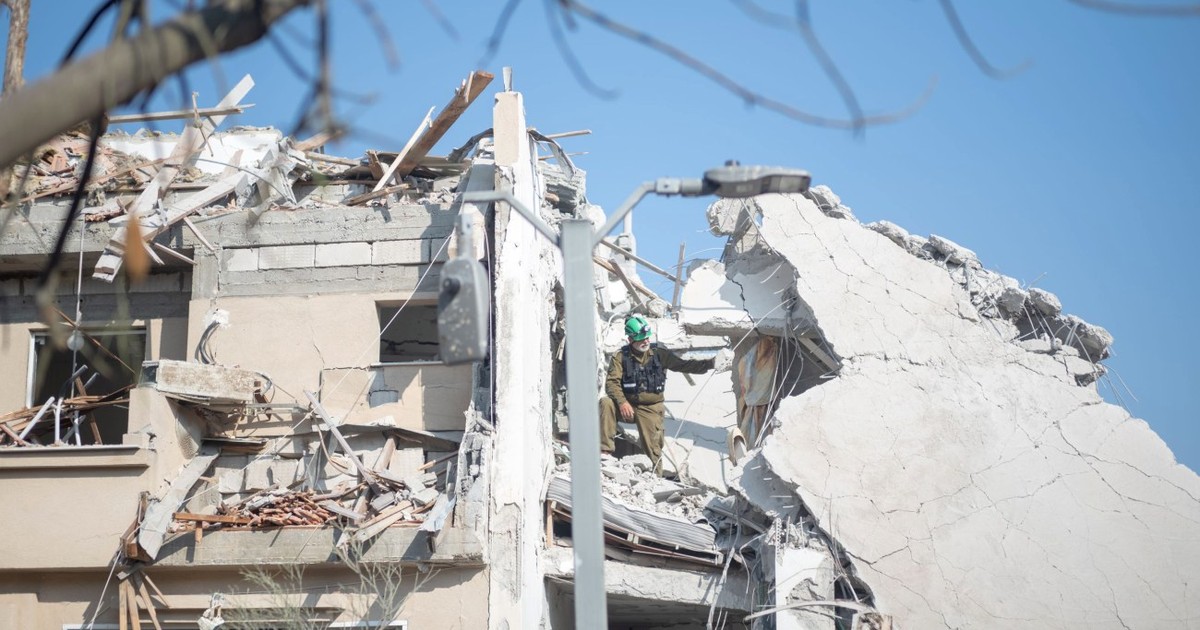 Muncitor israelian, cautand victime intr-o clădire distrusă după ce o rachetă iraniană a lovit o regiune din Israel
