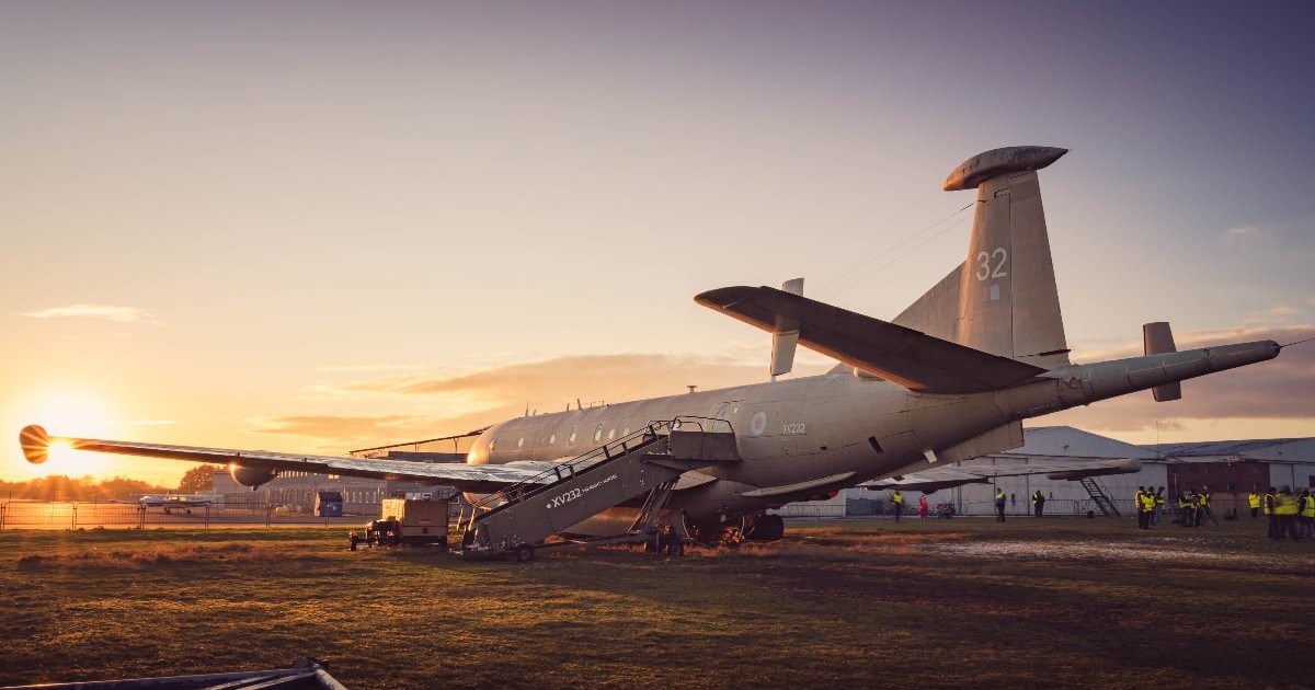 Imaginea surprinde o aeronavă staționată pe pista Aeroportului Coventry la apus, într-un cadru care evidențiază infrastructura istorică a aeroportului britanic.