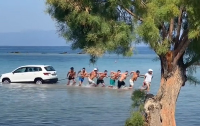 Momentul în care un SUV lăsat fără frâna de mână trasă cade în mare, în Grecia. Turiștii s-au chinuit să salveze mașina