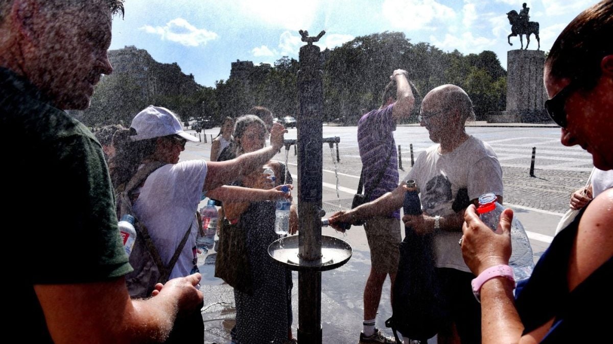 Turiștii și parizienii se răcoresc la Turnul Eiffel, în timpul unui val de căldură, Paris, 22 iunie 2026