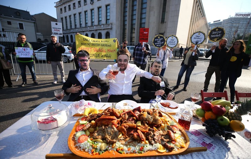 Protest în timpul ședinței de Guvern pe tema salariului minim european. „Ciucă”, „Ciolacu” și „Budăi” au luat masa în Piața Victoriei