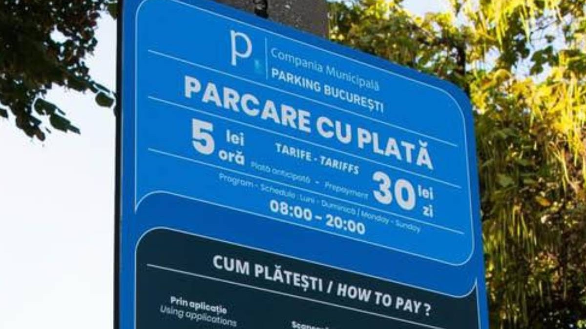 panou metalic pe care scrie parcare cu plata si sunt prezentate tarifele pentru o ora sau o zi