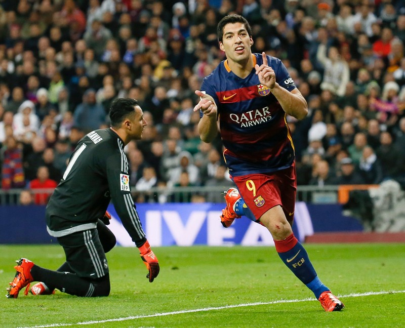 epa05036321 FC Barcelona's Uruguayan striker Luis Suarez (R) celebrates after scoring the 0-4 lead next to Real Madrid's Costa Rican goalkeeper Keylor Navas (L) during the Spanish Liga Primera Division soccer match played at Santiago Bernabeu stadium in Madrid, Spain, 21 November 2015. EPA/JuanJo Martin