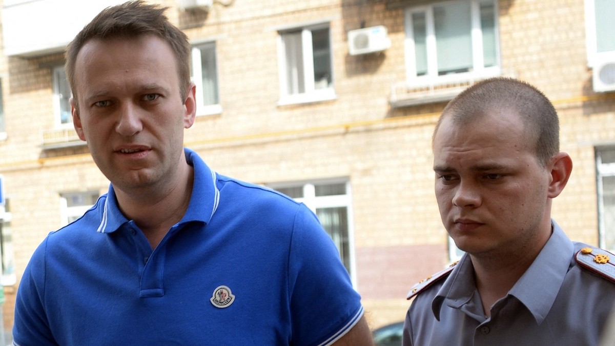 Aleksei Navalnîi, în stânga, alături de un ofițer de poliție rus, în fața unui tribunal din Moscova, în 2014