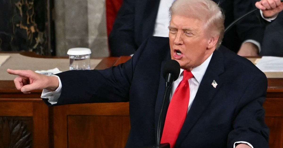 Donald Trump, furios arătând cu degetul în partea stanga a fotografiei, îmbrăcat într-un costum negru, cu o cămașă albă și o cravată roșie
