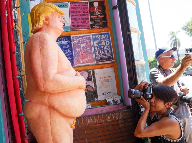 epa05497427 A naked Donald Trump statue gets the attention of passersby after being unveiled around the USA including in Los Angeles, California, USA, 18 August 2016. The unauthorized art installation was created by INDECLINE, a self-described anarchist group. The other cities where the statues appeared in the morning were San Francisco, Seattle, Cleveland and New York. EPA/EUGENE GARCIA