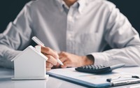 Un bărbat calculează taxele și impozitele pentru locuințe