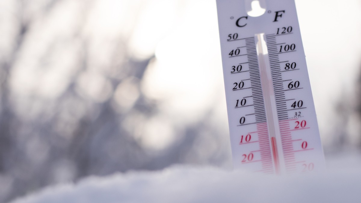 Un termometru în zăpadă care arată temperaturi negative.