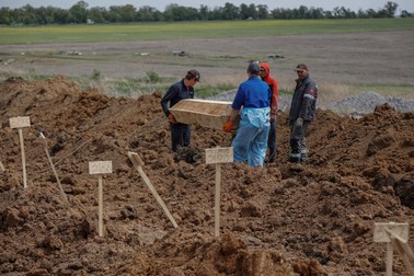 Lucrătorii cimitirului poartă un sicriu într-un cimitir din satul Staryi Krym, la periferia orașului Mariupol, regiunea Donețk, 21 mai 2022. Foto: EPA