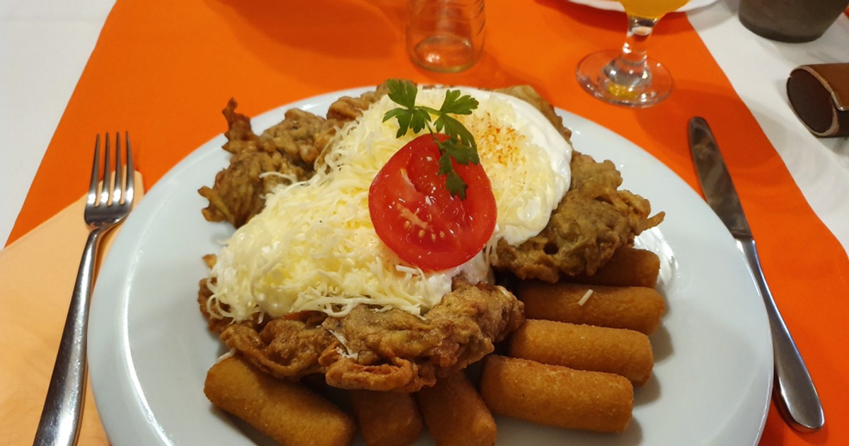 Mátrai borzaska - reţetă ungurească de şniţel - Imagine cu un şniţel matrai borzaska pe un pat de crochete, totul pe o farfurie întinsă.
