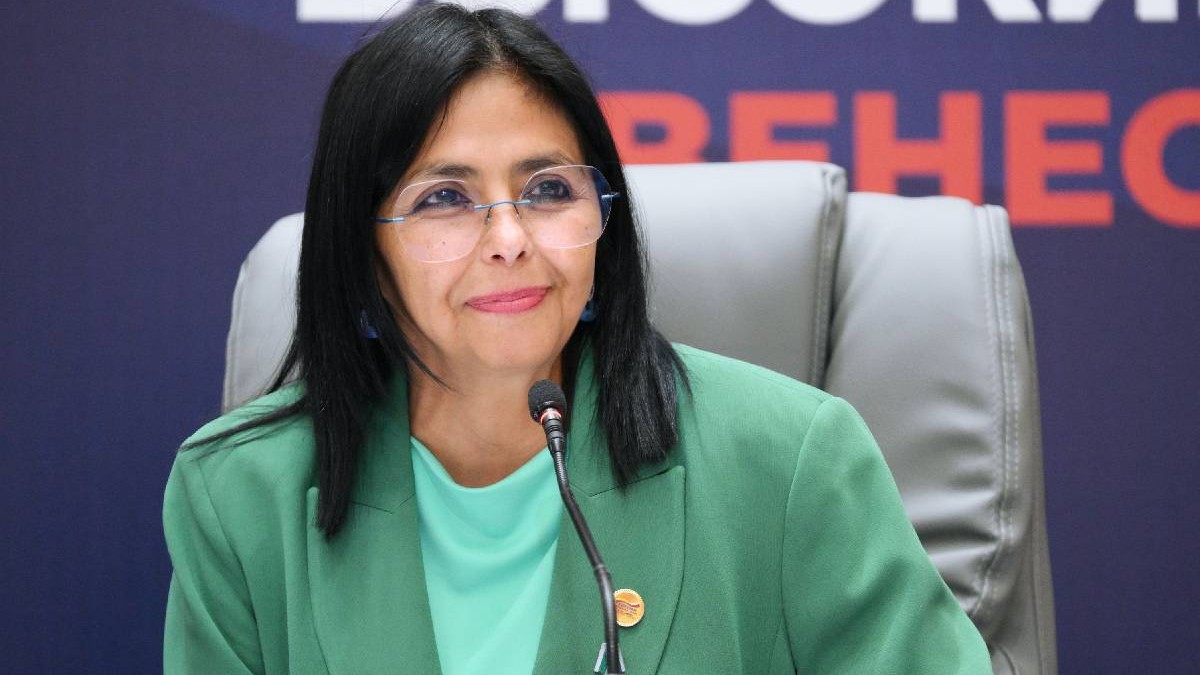 Delcy Rodriguez, cu o bluză verde și un sacou asortat, în timpul unei conferințe, se pregătește să ia cuvântul