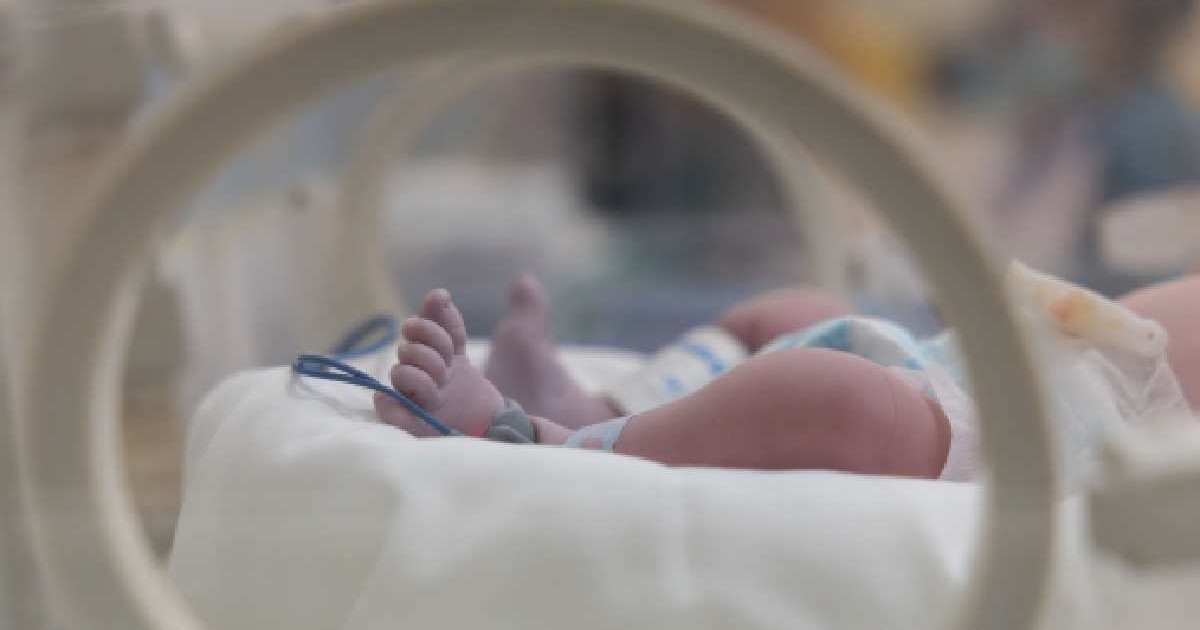 Picioarele unui copil sunt vizibile într-un incubator de spital.