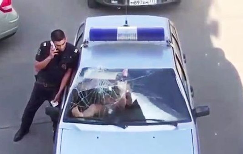 Se întâmplă doar în Rusia! O femeie în costum de baie, care a fost arestată, sparge parbrizul mașinii de poliție | VIDEO