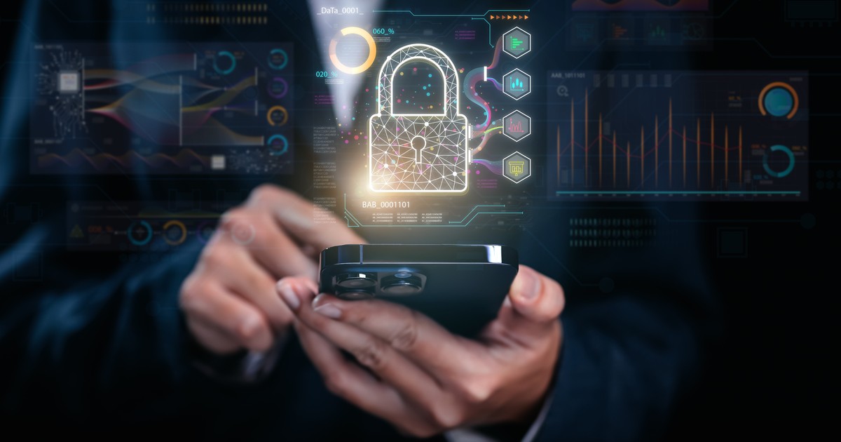 securitate online: un barbat care tine un telefon in mana, cu un lacat reflectat deasupra telefonului.
