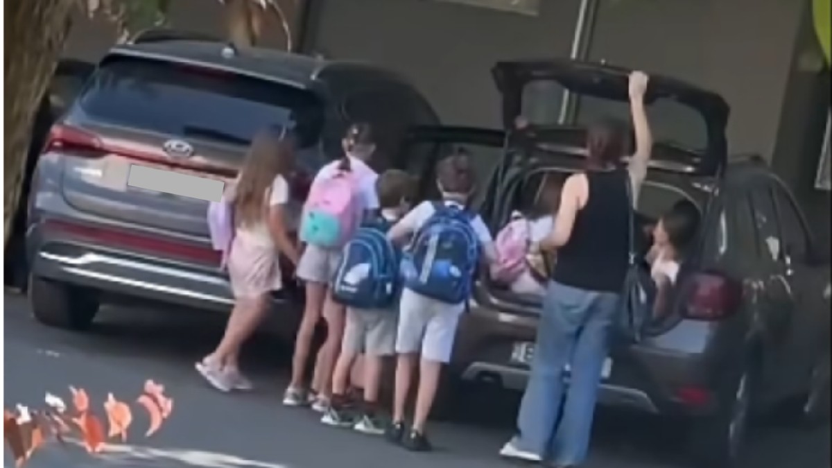Copii care stau lângă mașini. Unii sunt băgați într-un portbagaj.