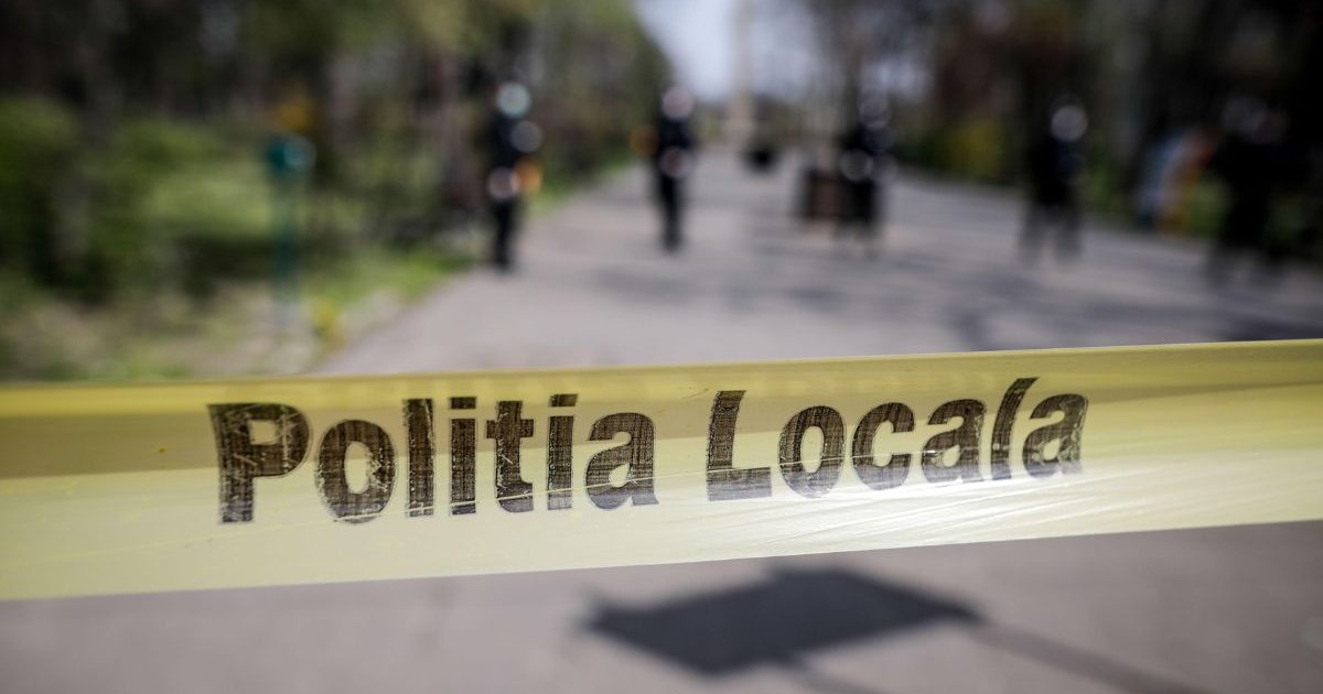 banderolă galbenă cu textul „Poliția locală” prinsă în capătul unei străzi pietruite