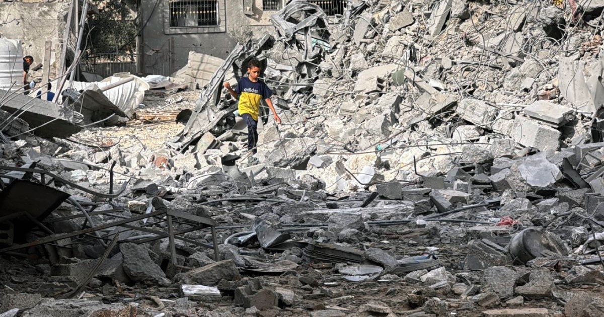 Un băiat palestinian caută prin molozul unei case distrusă de atacurile aeriene israeliene, Fâșia Gaza, 1 iulie 2025.