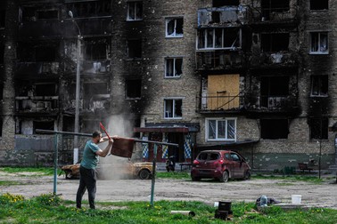 8 mai 2022, Ucraina, Irpin: Un bărbat curăță un covor de lângă o zonă rezidențială distrusă care a fost avariată în urma bombardamentelor armatei ruse. Rusia a invadat Ucraina la 24 februarie 2022. Foto: Hepta