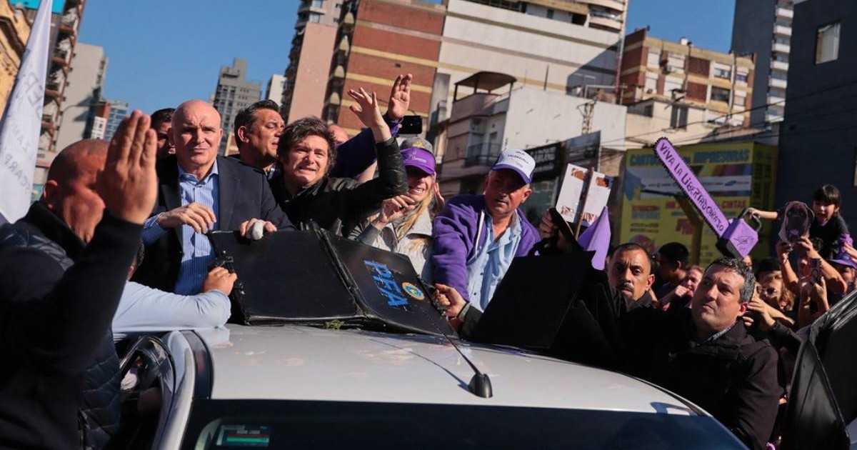 Președintele argentinian Javier Milei și echipa de campanie în mașina electorală albă, aceasta este atacată de mai mulți protestatari care încearcă să ajungă la șeful statului