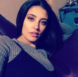 Antonia, serioasă, îmbrăcată într-un sarafan de culoare neagră cu o helancă gri