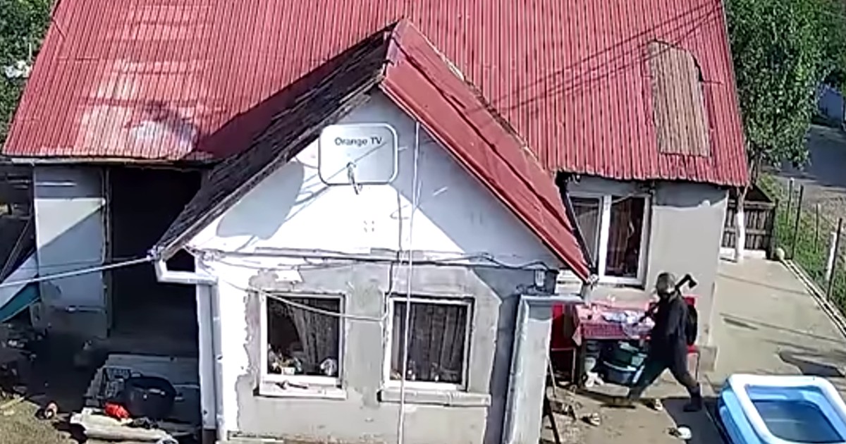 Un bărbat cu toporul pe umăr, în curtea unei case. Foto Captură video Recorder