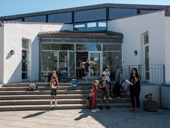 Profesoara Maria Vasile și copii români în fața școlii din Skagen