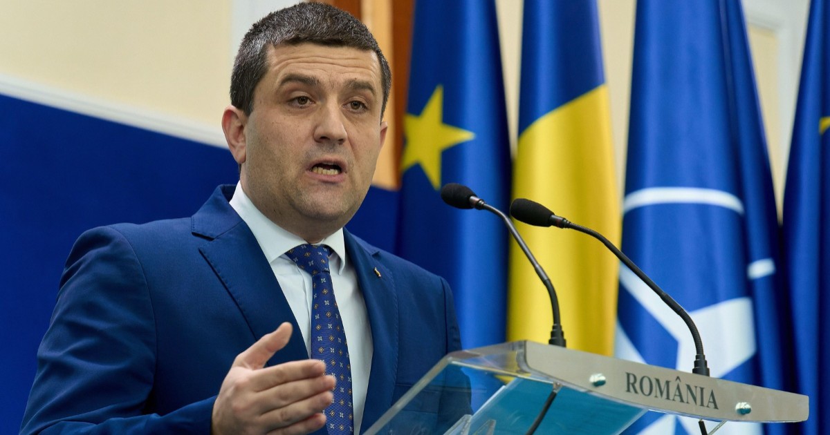 Ministrul Apărării, Radu Miruță, în timpul unei conferințe de presă. Vorbește la microfon și gesticulează