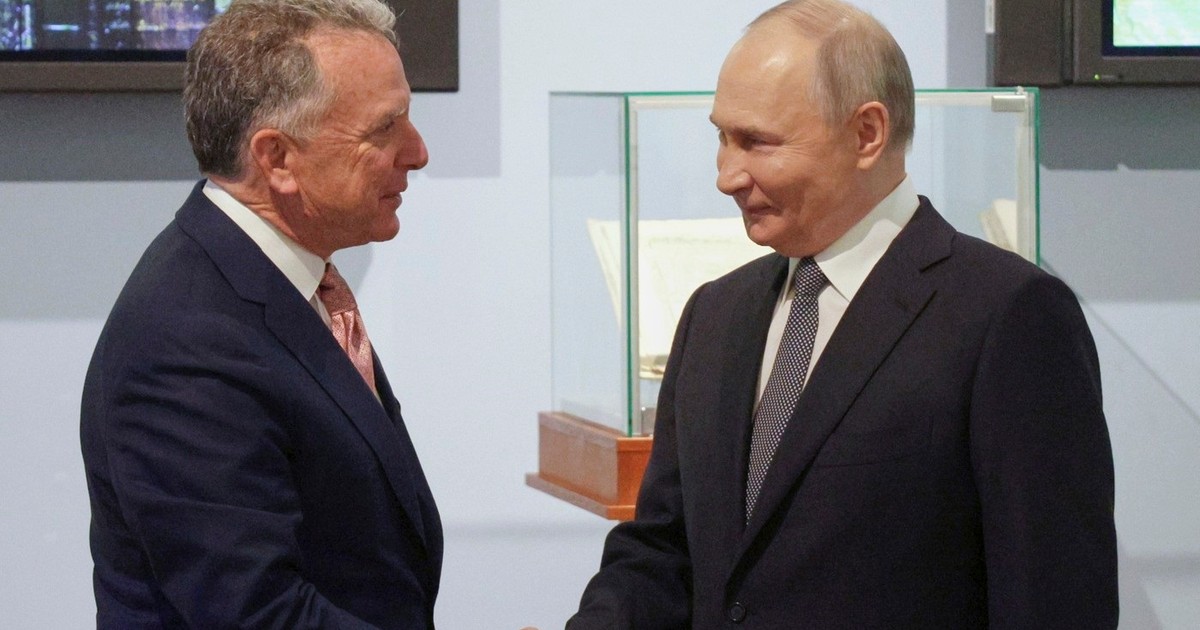 Vladimir Putin zâmbește, în dreapta, în timp ce dă mâna cu trimisul lui Donald Trump, Steve Witkoff