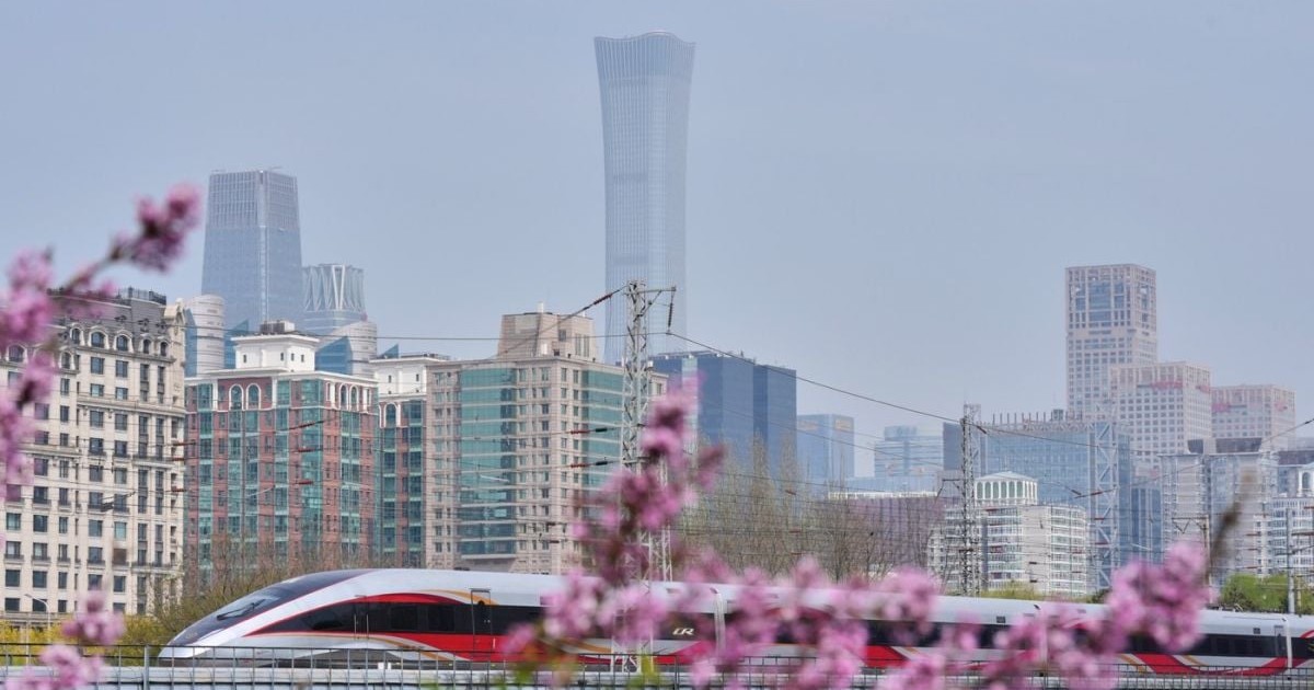 Un tren de mare viteză CRH trece pe lângă cel mai înalt zgârie-nori al capitalei, China Zun Tower, și clădiri de birouri în timp ce se apropie de gara din Beijing, joi, 2 aprilie 2026