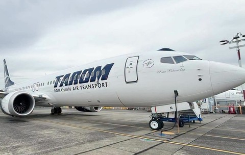 O aeronavă albă TAROM (cu numele de botez „Ivan Patzaichin” inscripționat în partea din față) staționată pe pista unui aeroport.