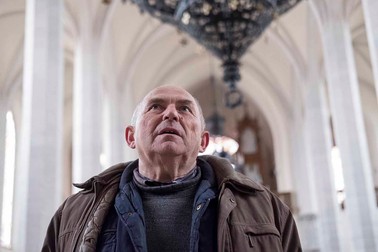 Andras bacsi cantă un imn bisericesc ce răsună puternic în biserica goală.