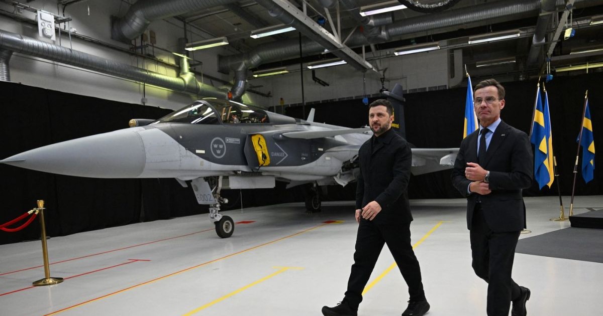 Prim-ministrul suedez Ulf Kristersson și președintele ucrainean Volodimir Zelenski trec pe lângă un avion de vânătoare Gripen, 22 octombrie 2025