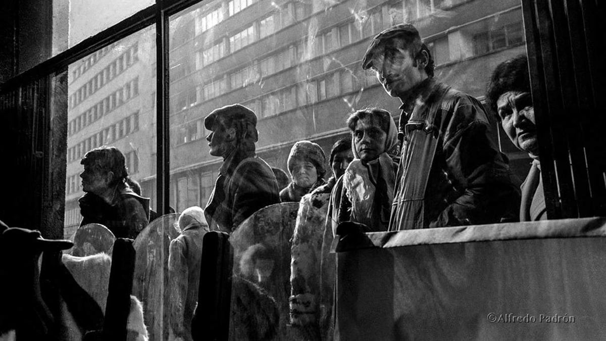 O fotografie alb negru care infatiseaza o multime de oameni uitandu se in vitrina unui magazin