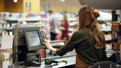 Cashier woman on workspace in supermarket shop