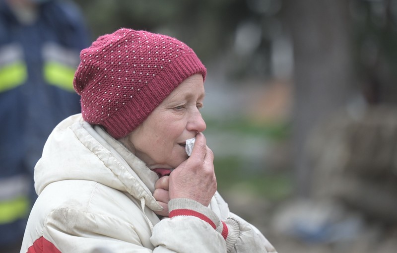 O femeie plânge în timp ce soldații scot cadavrele din teatrul din Mariupol | Foto: Ilya Pitalev / Sputnik